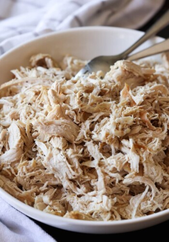 Shredded chicken breast in a bowl with forks
