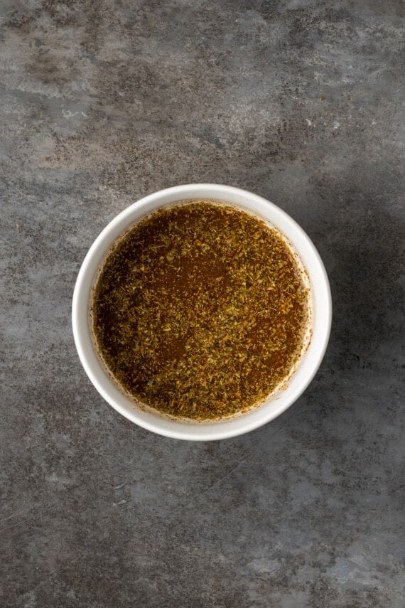 Seasoning combined with olive oil in a white ramekin.
