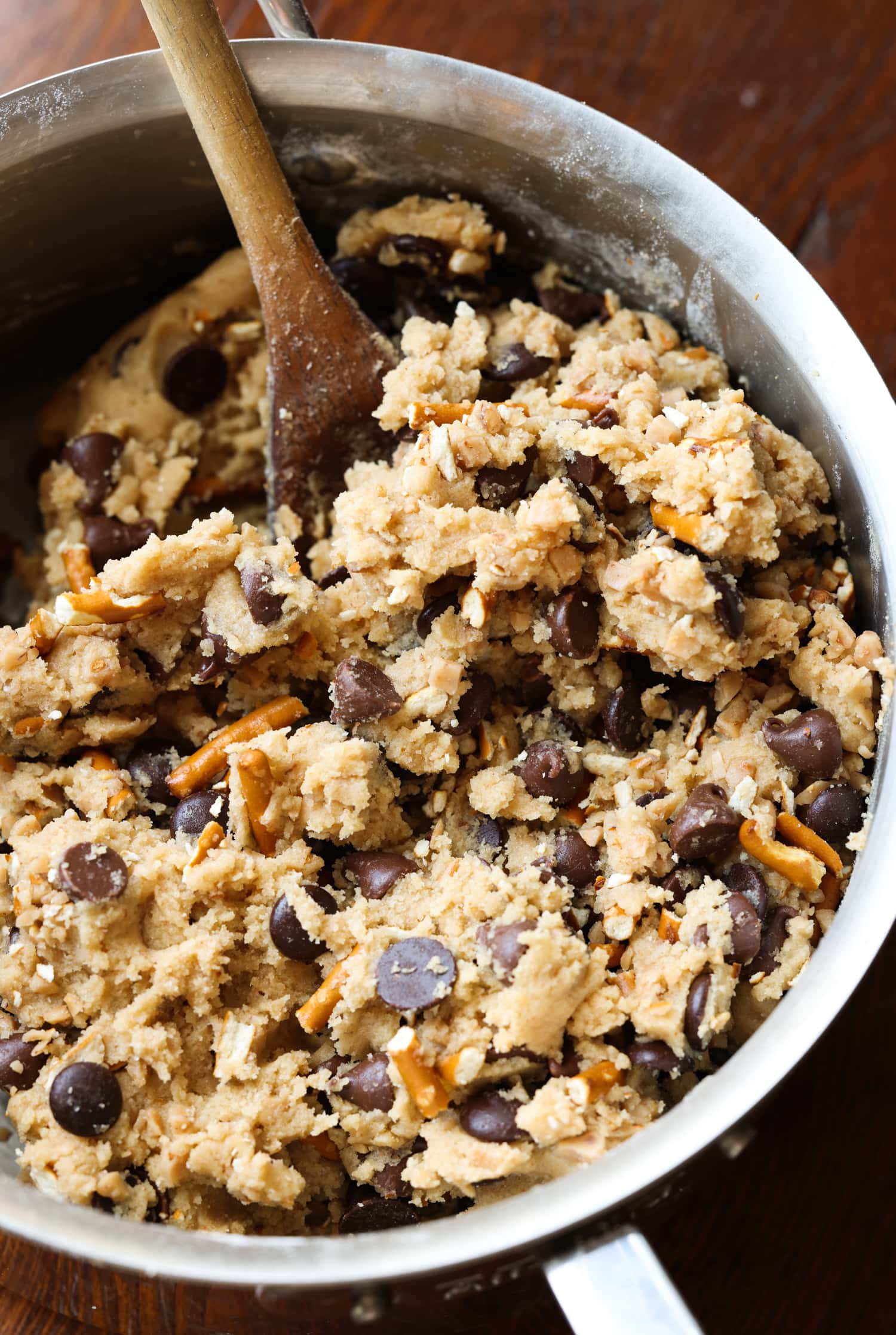 cookie dough with chocolate chips, toffee, and pretzels in a saucepan