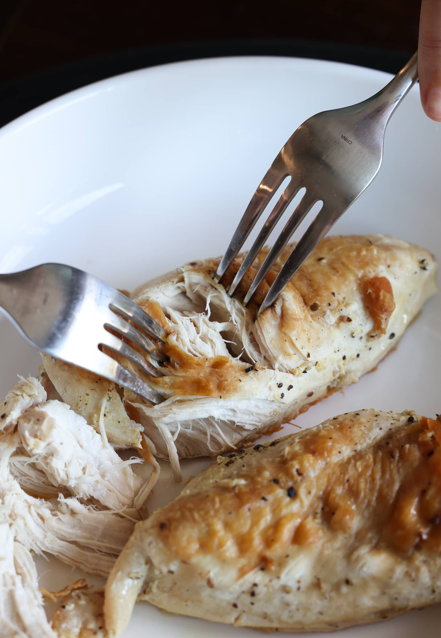 shredding cooked chicken breasts with forks