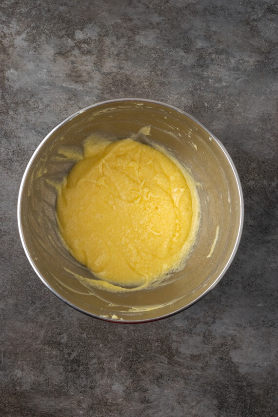 Sponge cake batter ingredients combined in a metal mixing bowl.