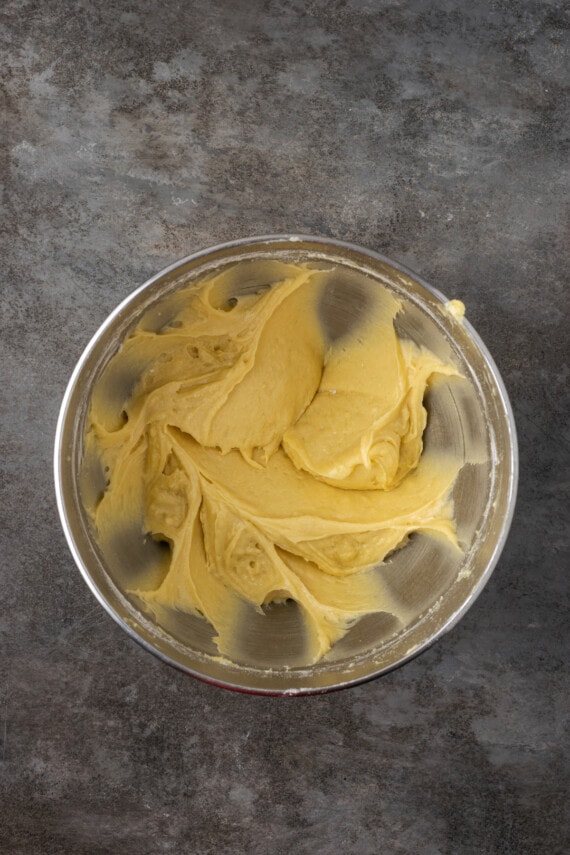 Beaten sponge cake batter in a metal mixing bowl.