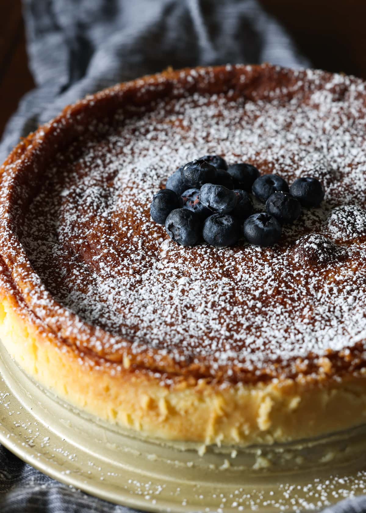 Flourless white chocolate cake dusted with powdered sugar and garnished with fresh blueberries.