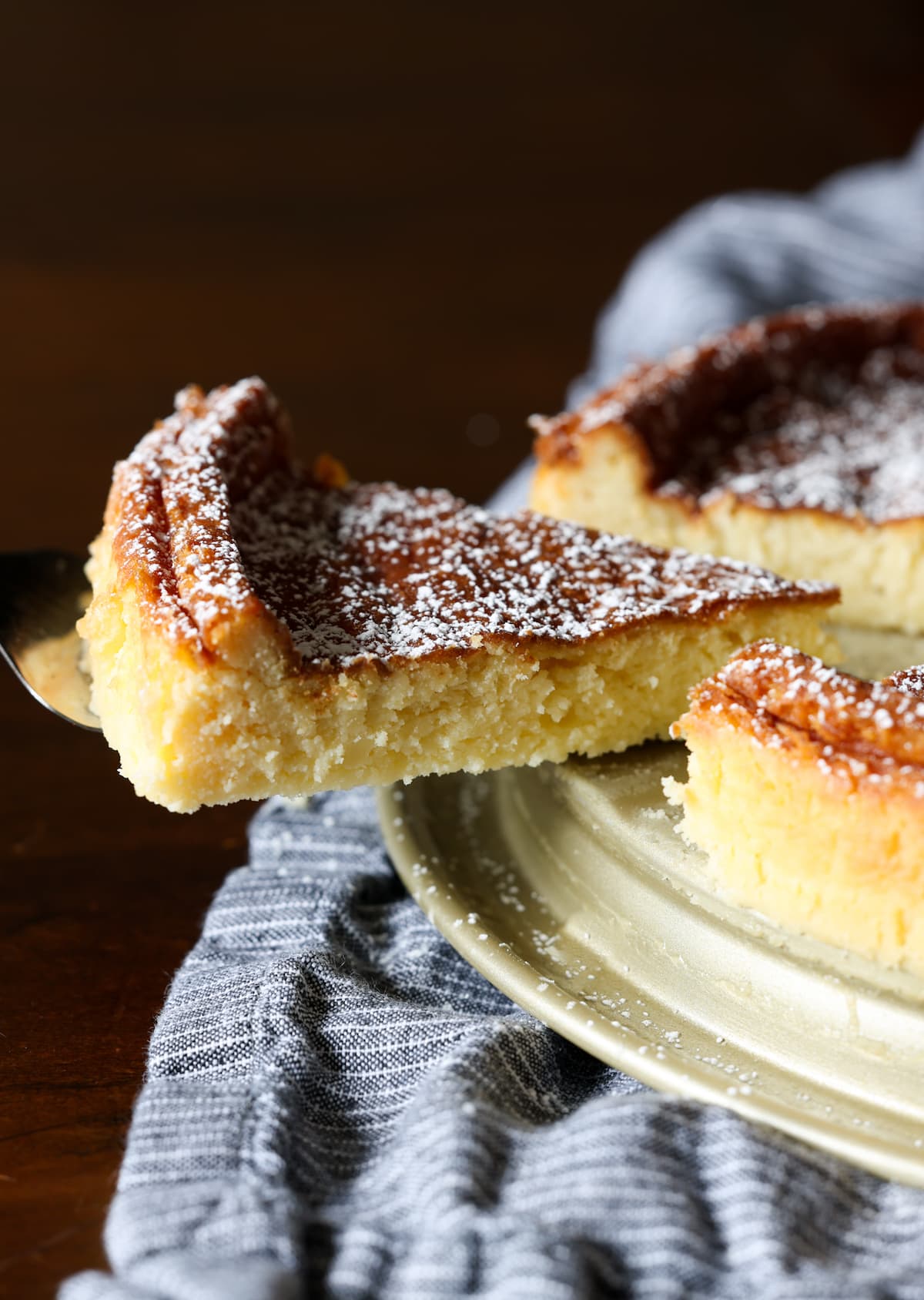 A slice is lifted from a flourless white chocolate cake.