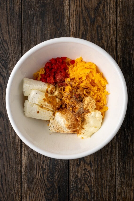Pimento cheese ingredients combined in a white bowl.