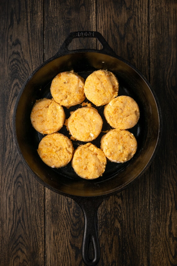 Eight cut out sweet potato biscuits inside a cast iron skillet.