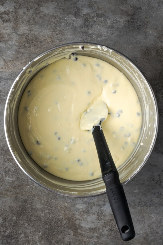 Cannoli cheesecake batter in a bowl with a spatula.