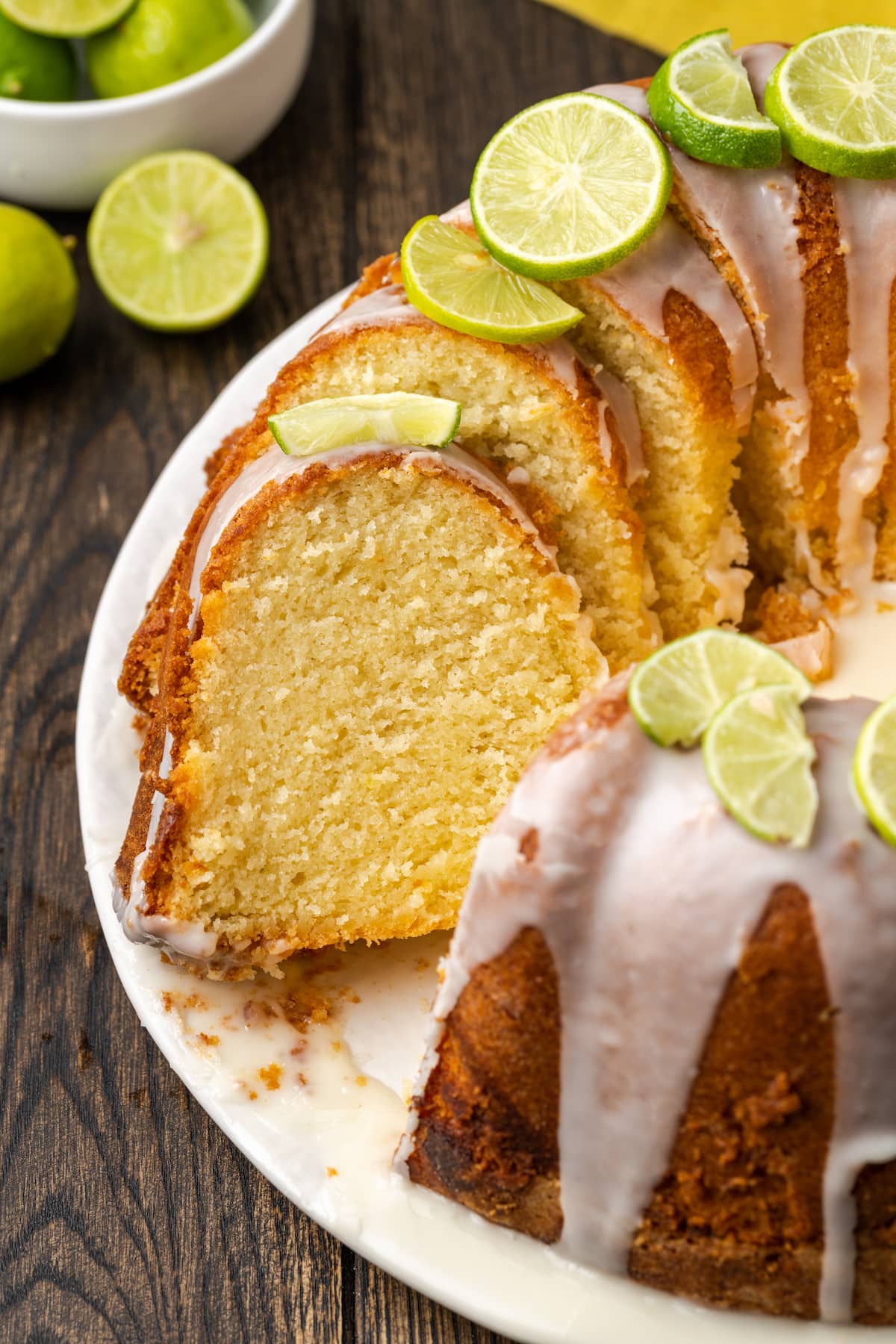 Key lime pound cake cut into slices, garnished with fresh limes.