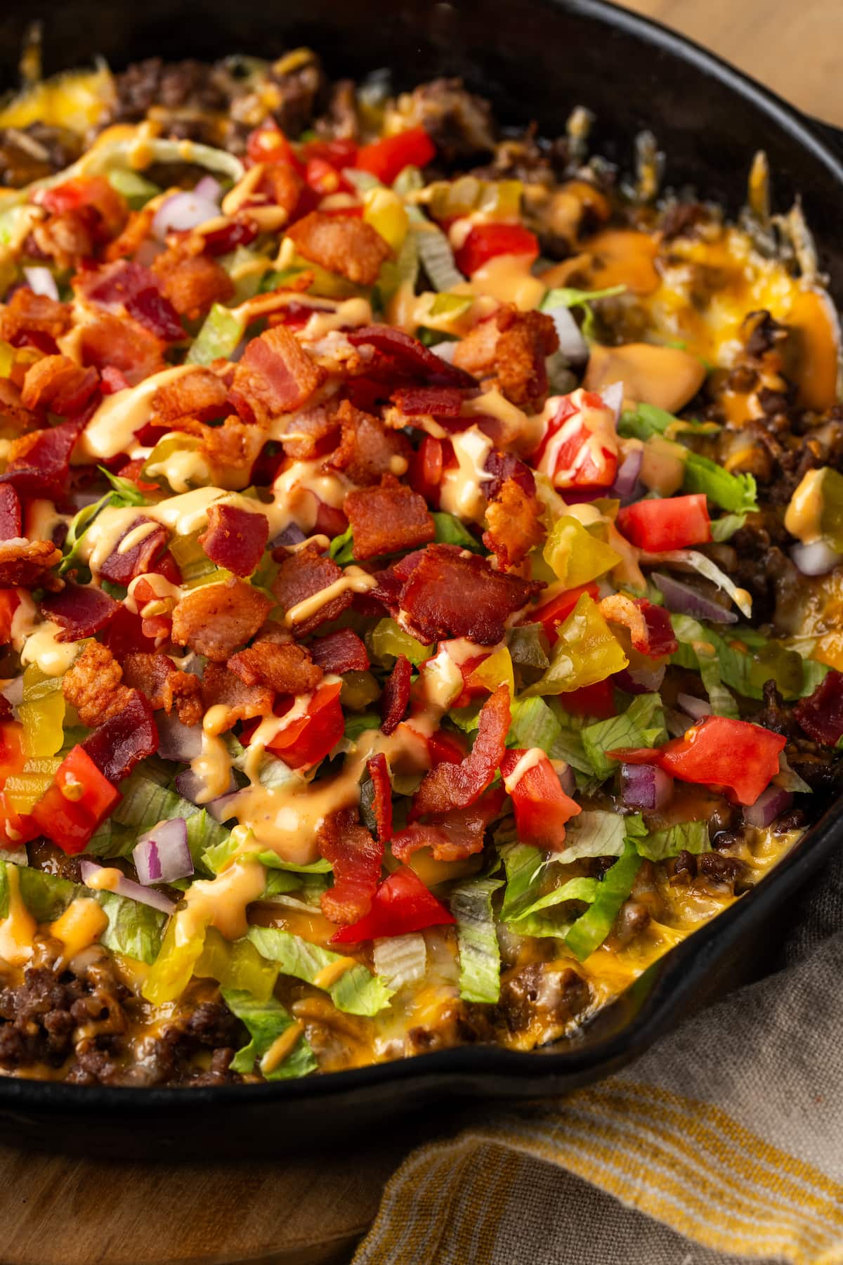 Close up view of a skillet of cheeseburger dip.