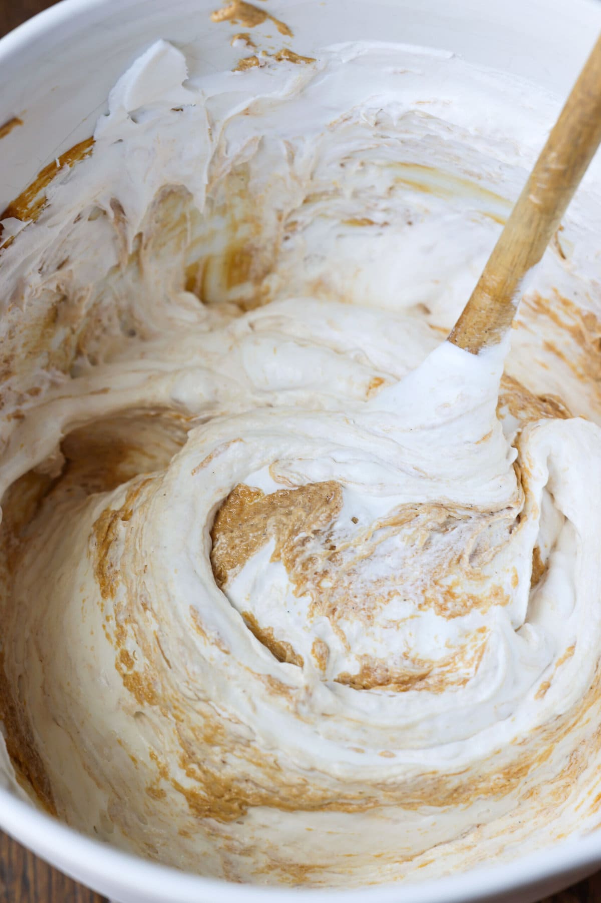 Fluffy cream cheese mousse with swirls of cookie butter spread in a mixing bowl