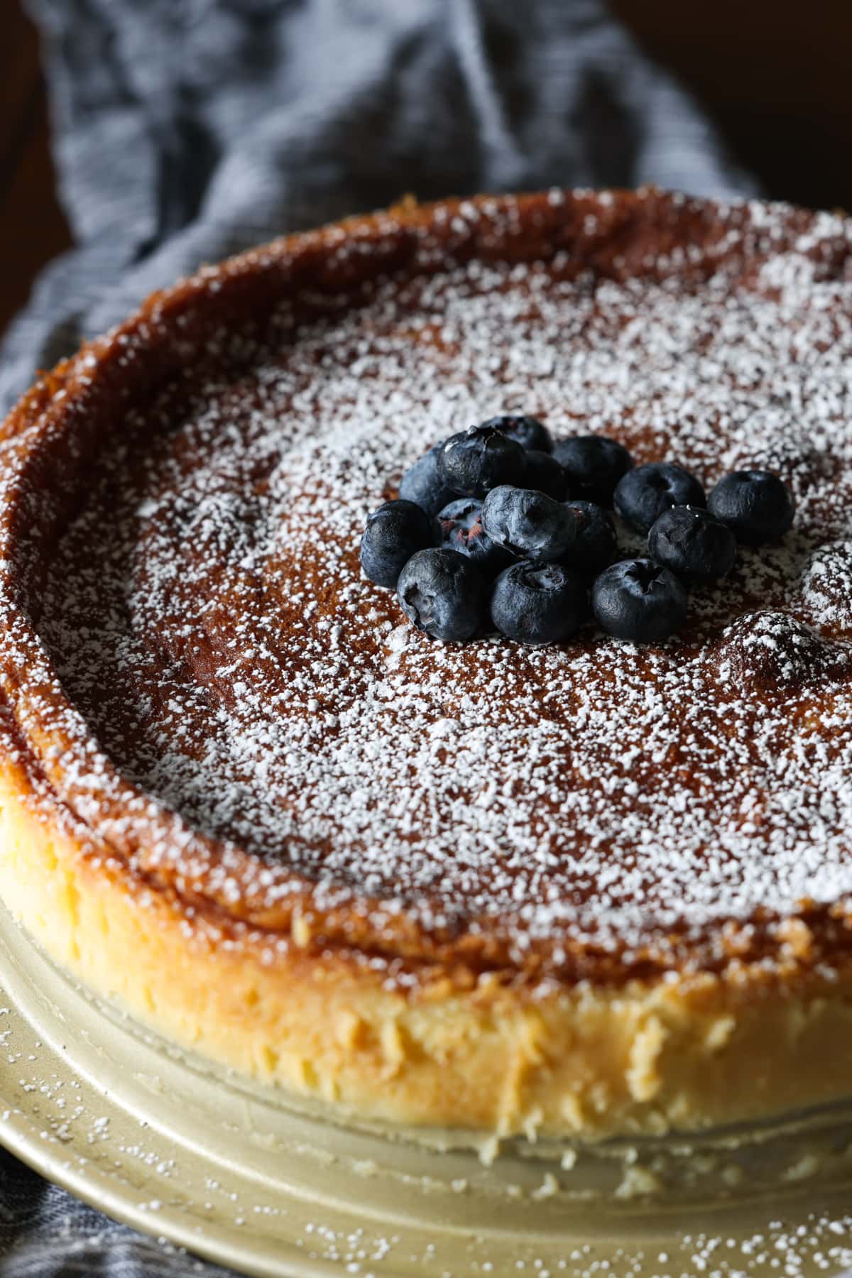 Flourless white chocolate cake dusted with powdered sugar and garnished with fresh blueberries.