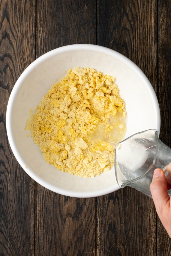 Hot water is poured into a mixing bowl with cornbread ingredients.