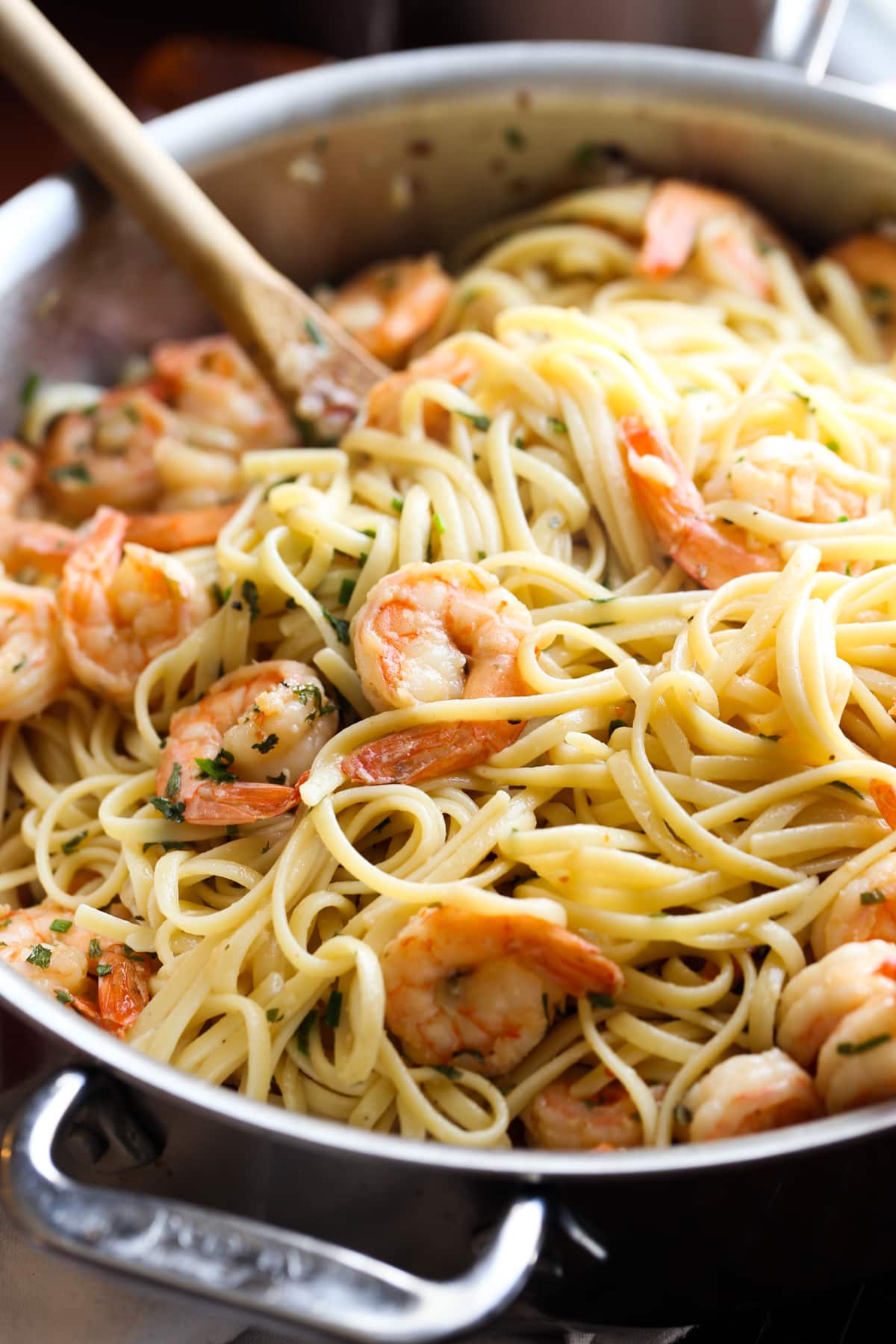 A stainless steel skillet filled with buttery pasta and shrimp