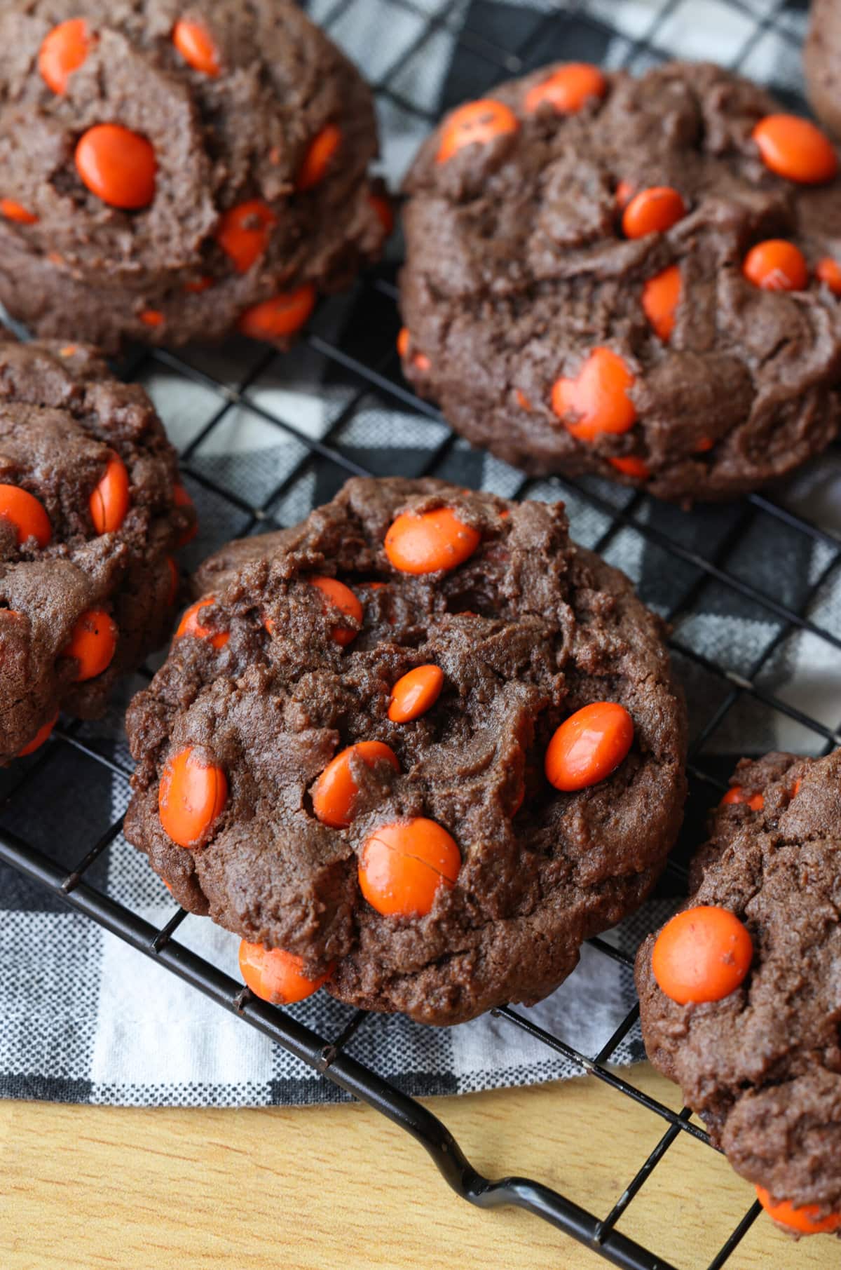 Dark Chocolate Cookies with orange M&Ms on a wire cooking rack