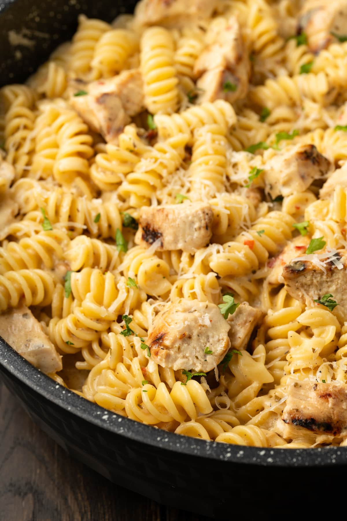 Close up of Buffalo Wild Wings garlic parmesan chicken pasta in a skillet.
