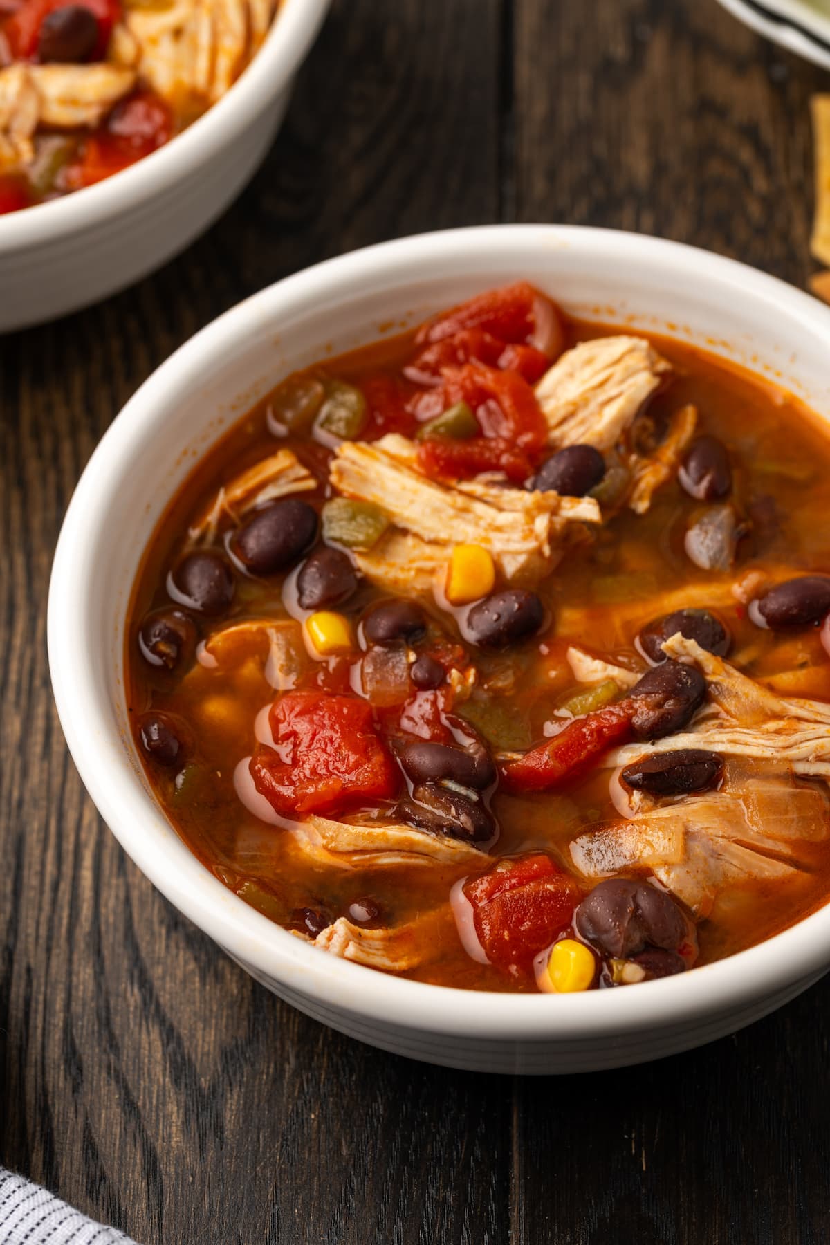 Close up of a bowl of Instant Pot chicken tortilla soup on a wooden countertop.