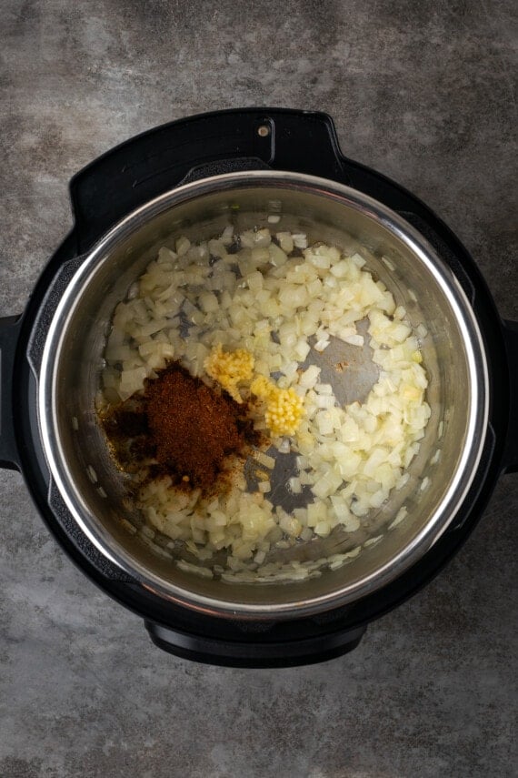 Taco seasoning added to the instant pot with sauteed onions.