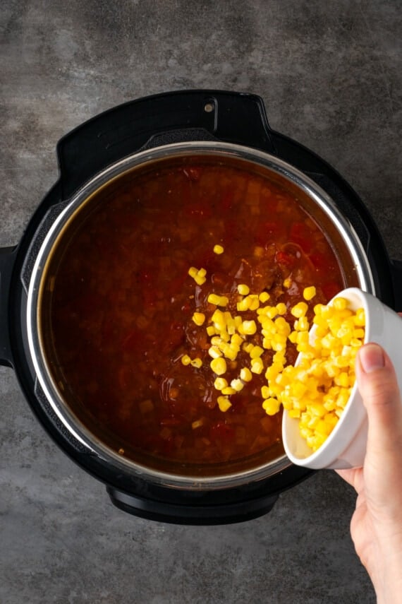 Sweet corn kernels are added to tortilla soup in the Instant Pot.