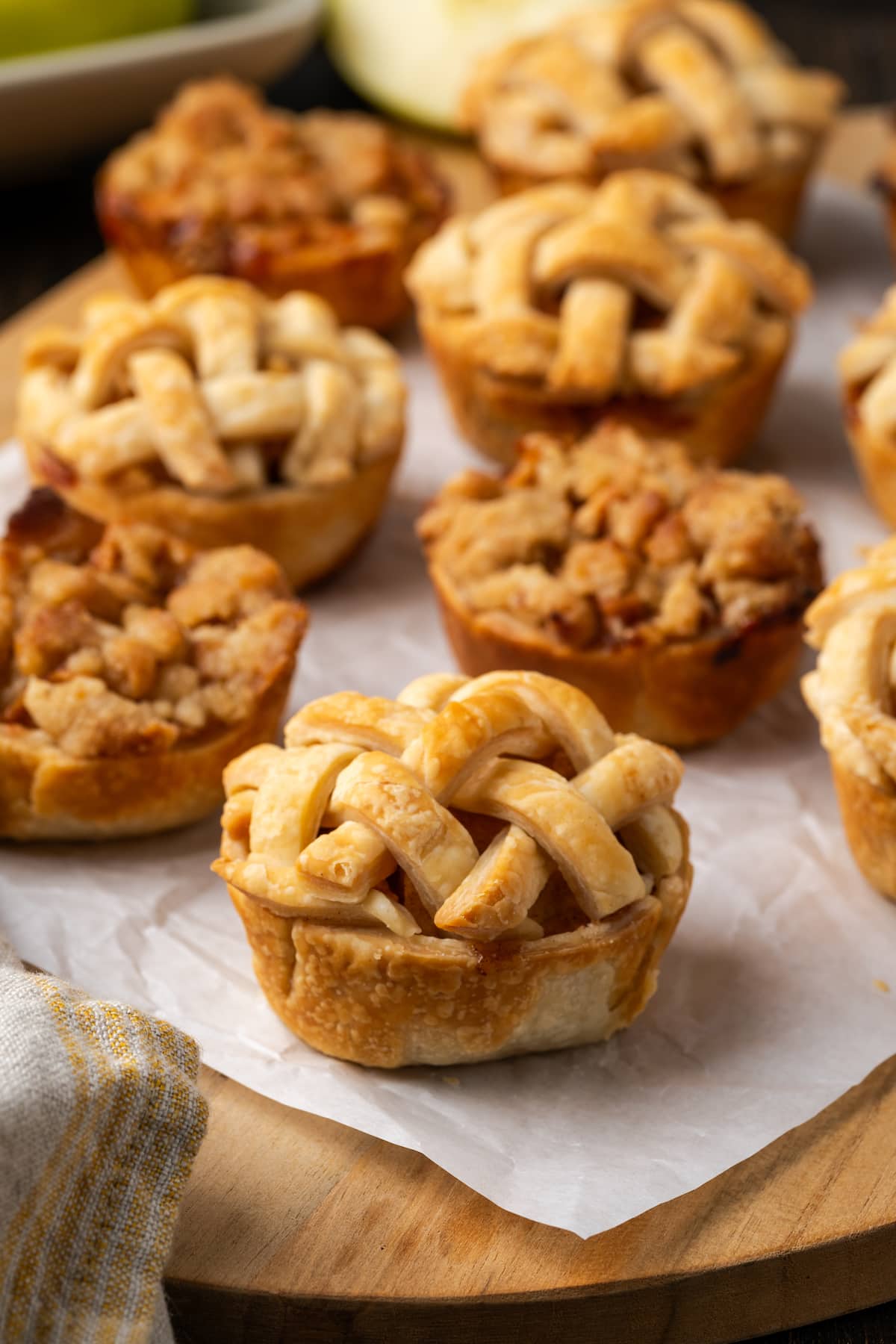 Mini apple pies on a piece of parchment paper.