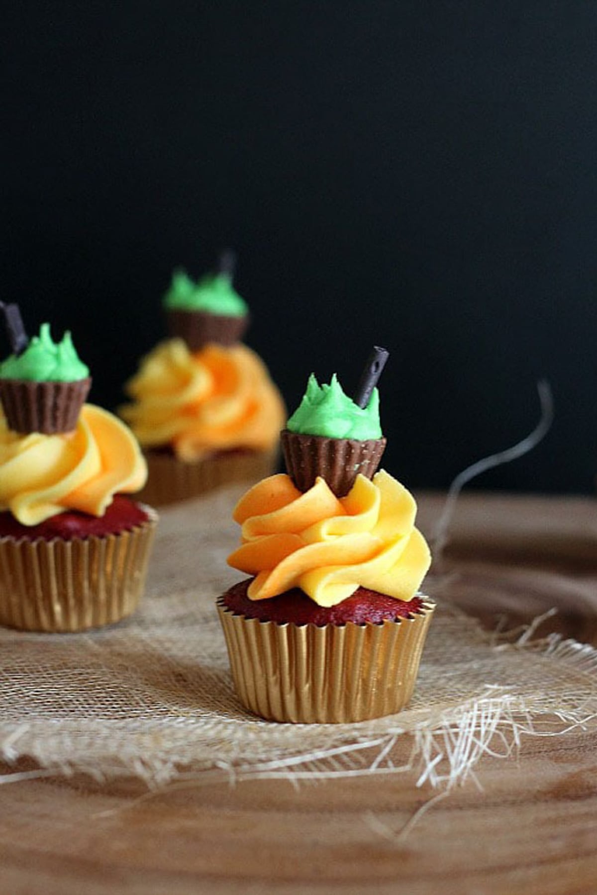 A red velvet cupcake topped with frosting to look like fire and a peanut butter cup cauldron