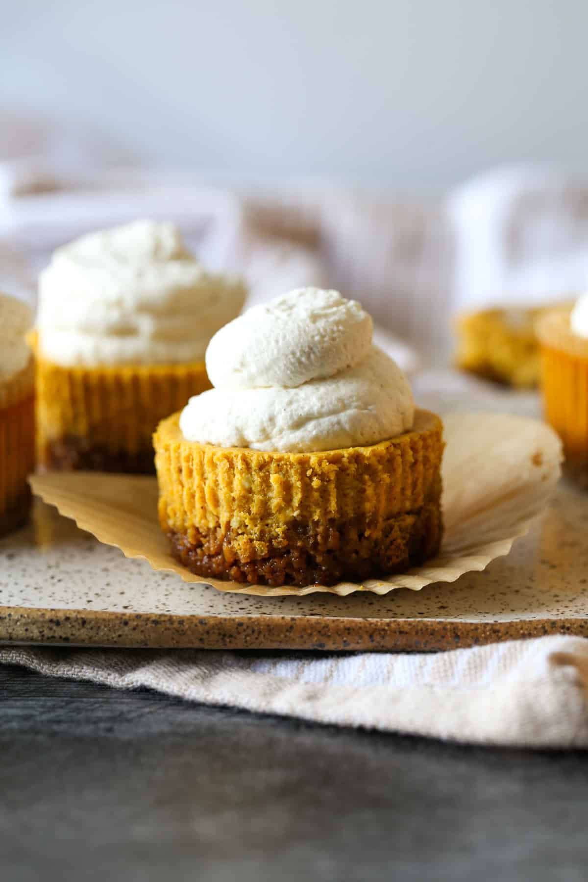 Mini Pumpkin Cupcake-style Cheesecakes on a serving plate unwrapped