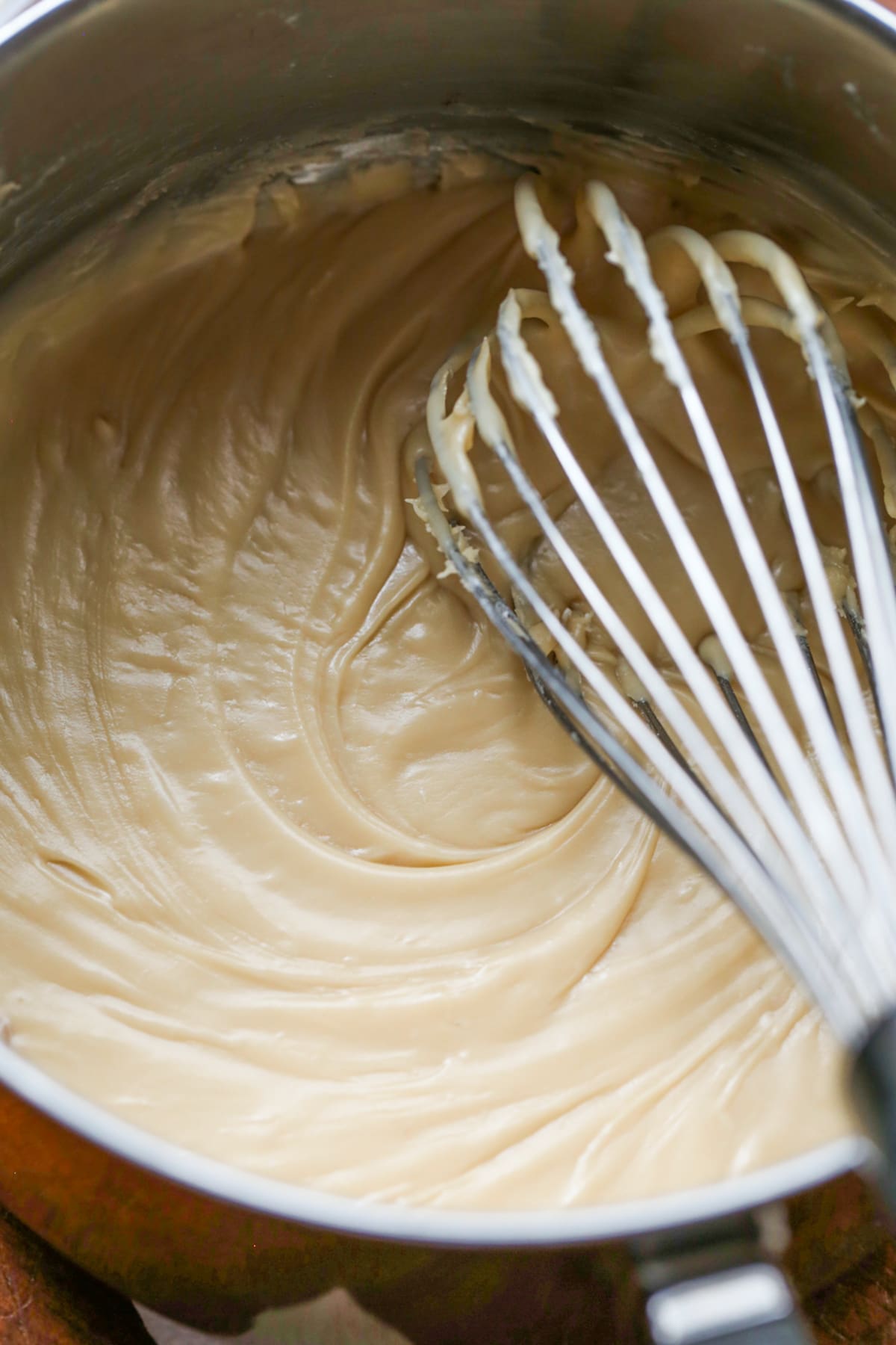 brown sugar icing in a saucepan with a whisk