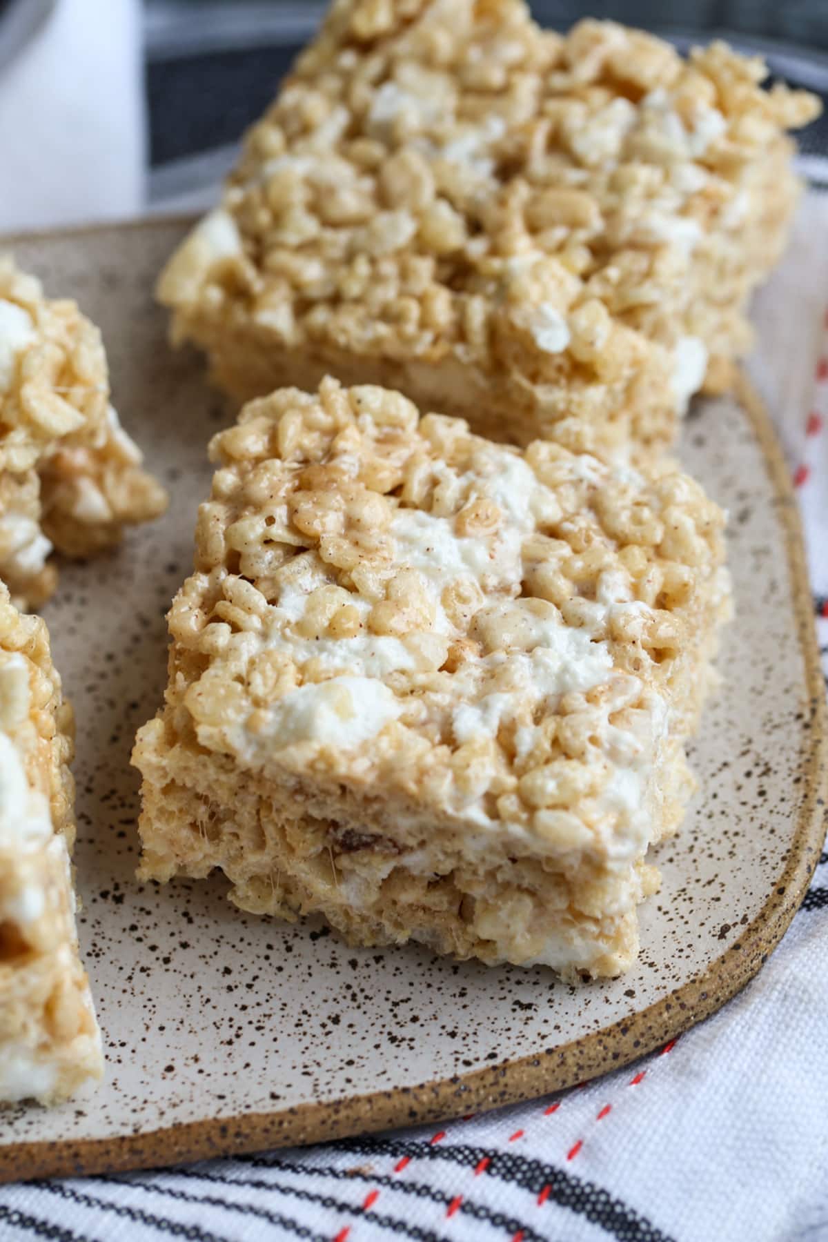 Rice Krispie Treats made with brown butter and pumpkin pie spice cut into squares on a plate