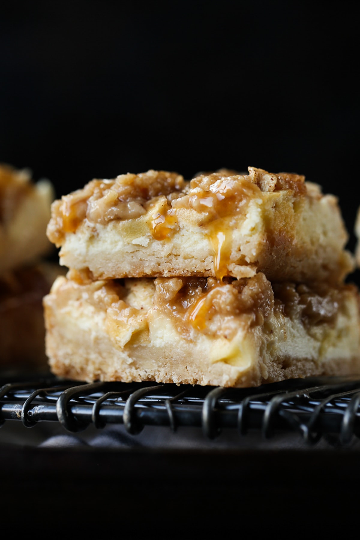 2 Apple Cheesecake Bars stacked on a wire rack