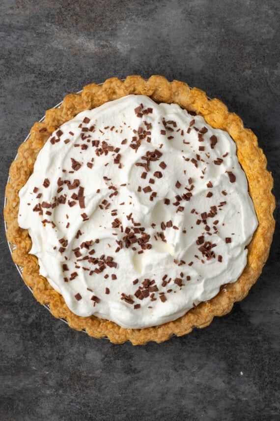 Chocolate pudding pie topped with whipped cream and shaved chocolate.
