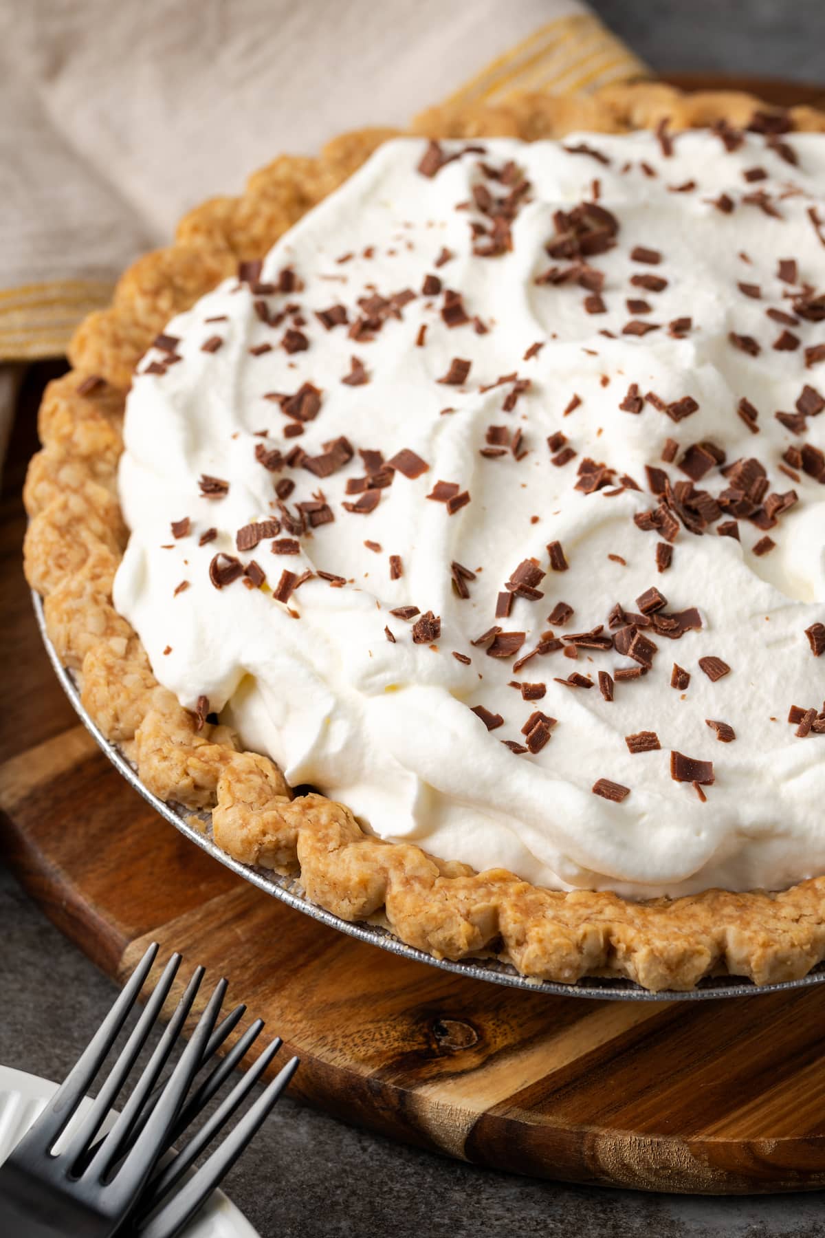 Chocolate pudding pie topped with whipped cream and chocolate shavings.