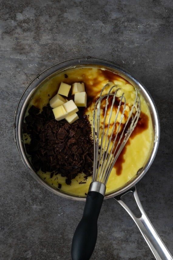 Chocolate and butter added to the pudding custard in a saucepan.