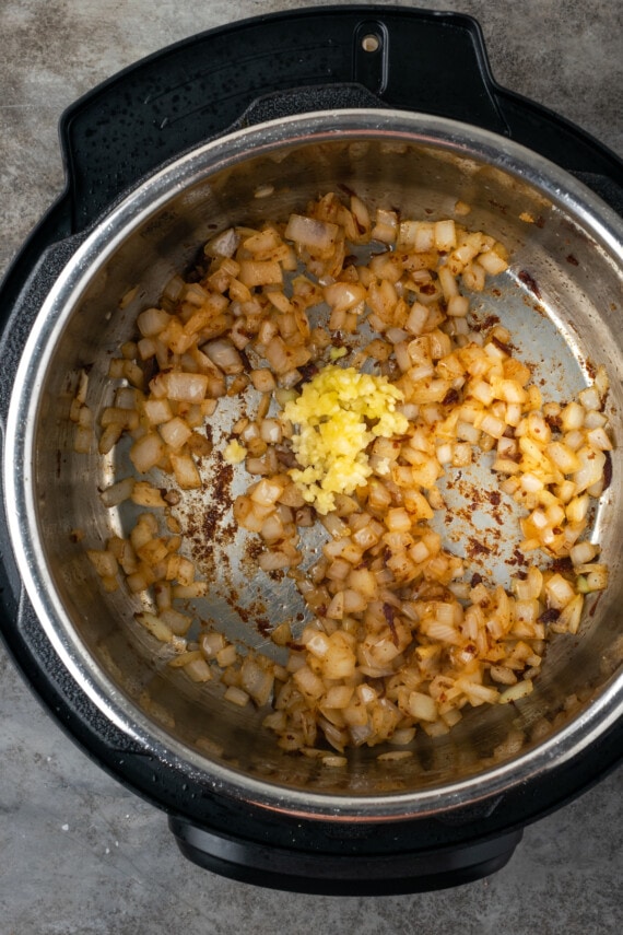 Minced garlic added to diced caramelized onions in the instant pot.