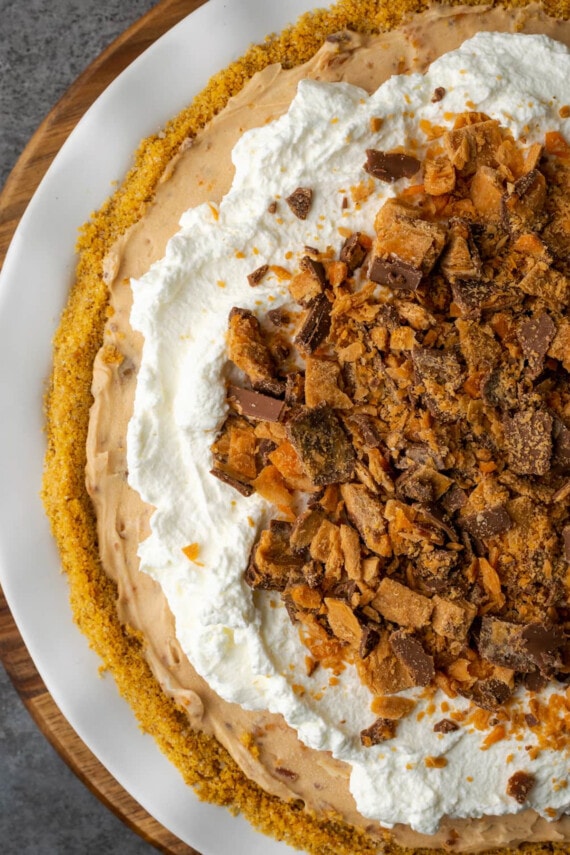 Top view of Butterfinger pie garnished with whipped cream and chopped Butterfinger candy bars.