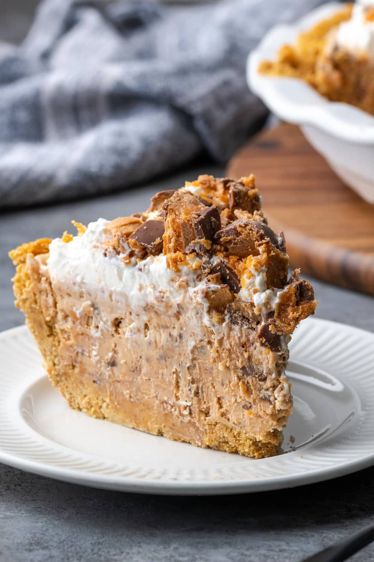 A slice of Butterfinger pie on a white plate.