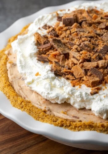 Butterfinger pie garnished with whipped cream and chopped Butterfinger candy bars.