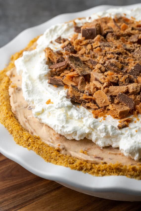 Butterfinger pie garnished with whipped cream and chopped Butterfinger candy bars.