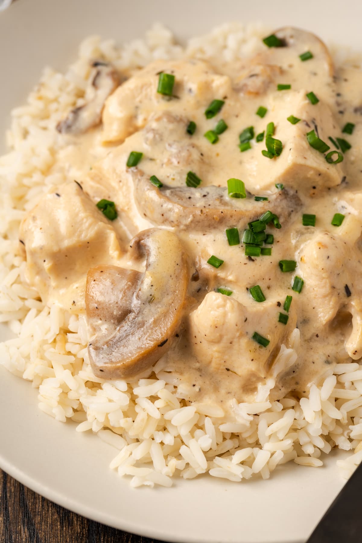 Close up of cream of mushroom chicken served over rice in a bowl.
