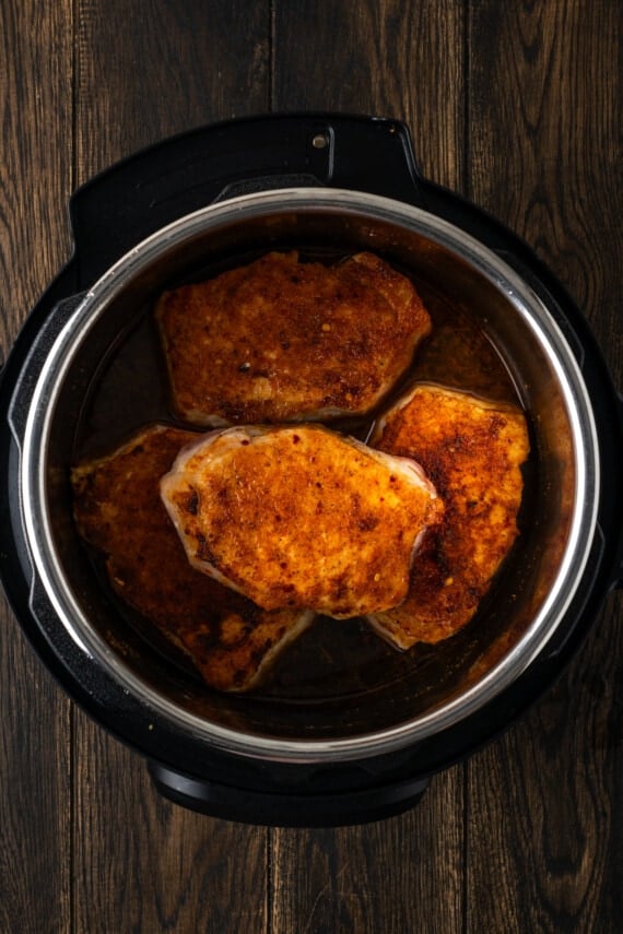 Instant Pot pork chops are tender, juicy, and full of flavor. Make a quick gravy out of the leftover cooking sauce for an easy weeknight meal! Cooked pork chops inside the instant pot.