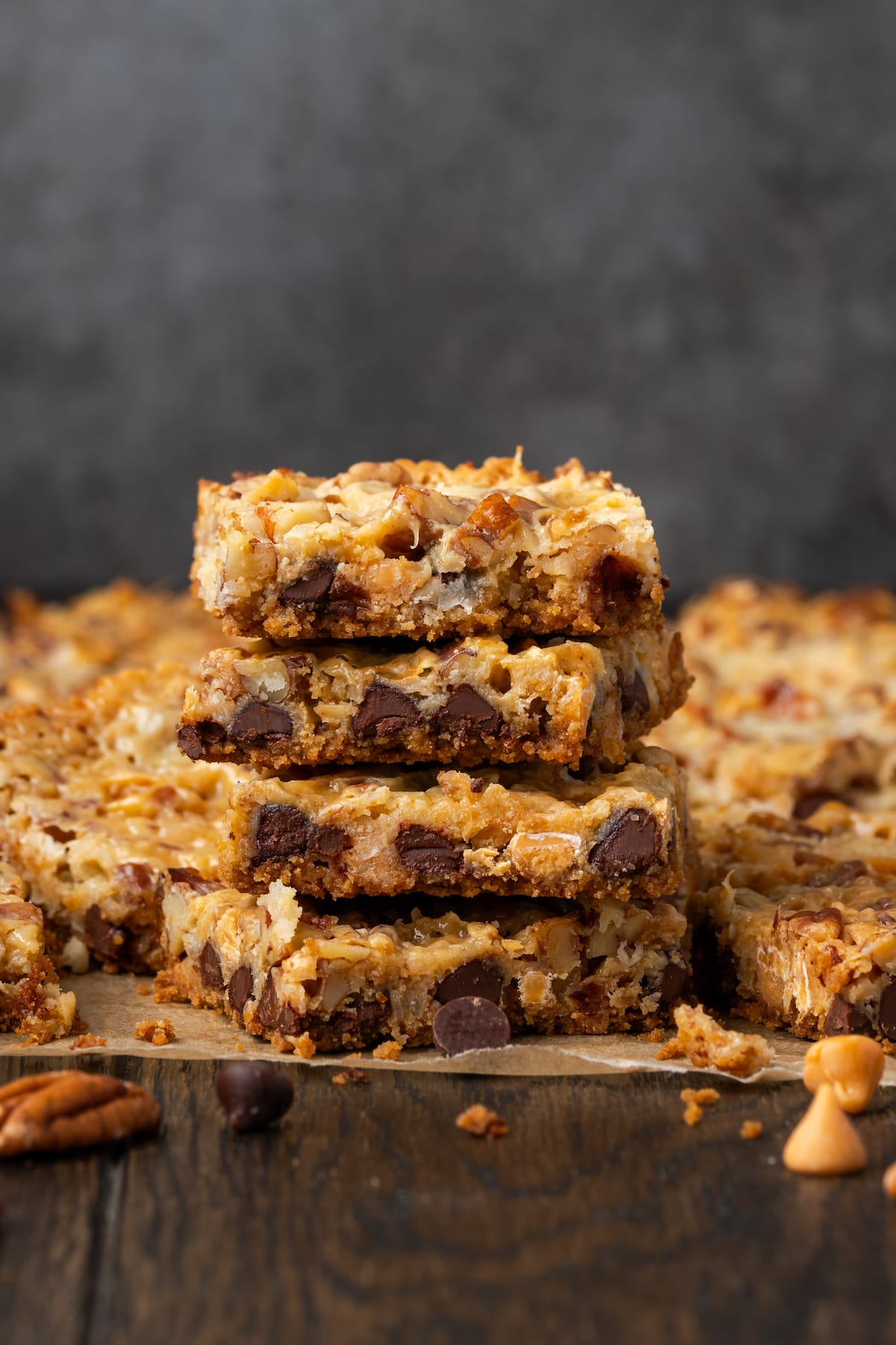 Side view of a stack of magic bars on a wooden countertop, with more bars in the background.