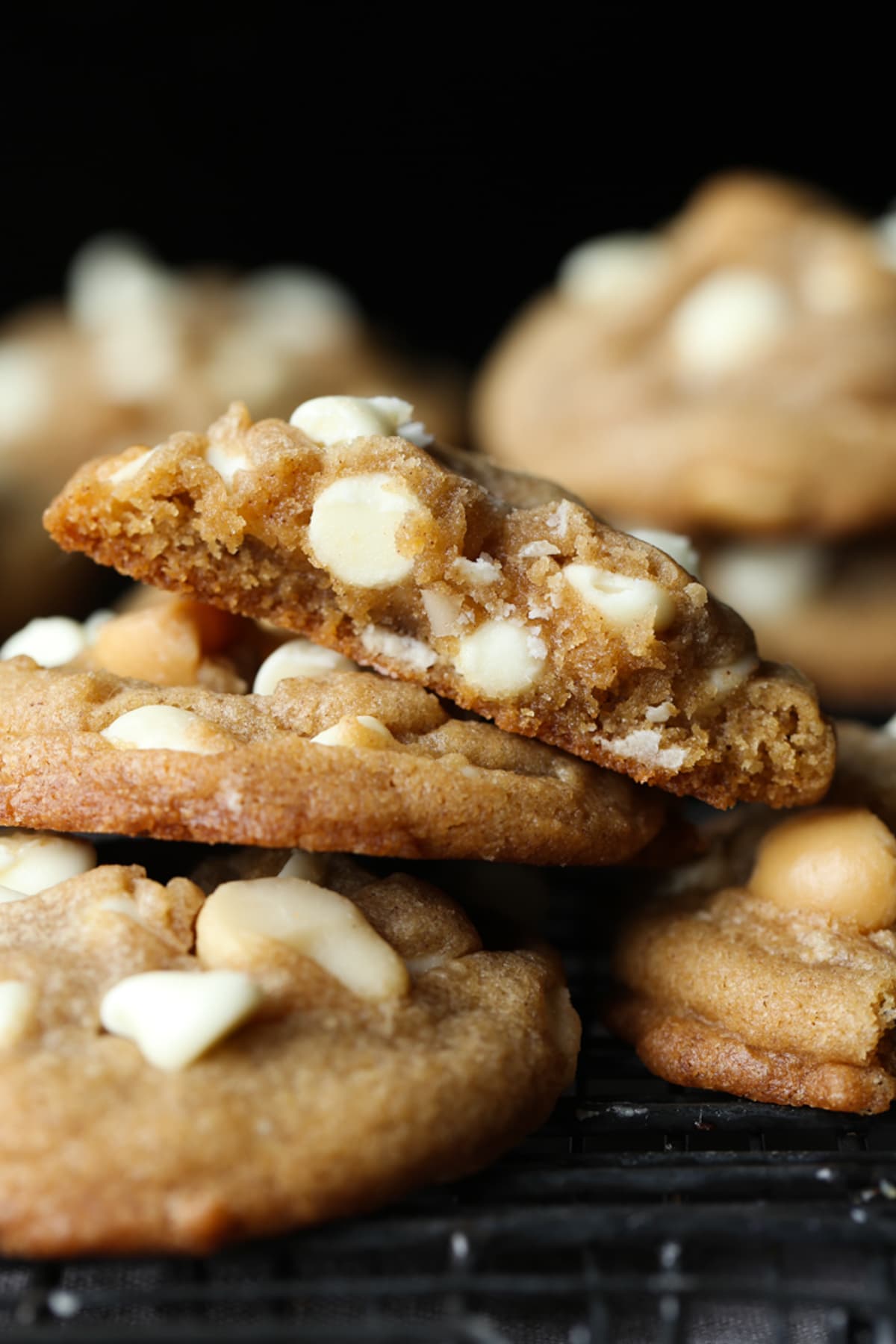 White Chocolate Macadamia Nut Cookies stacked and broken in half showing the gooey centers