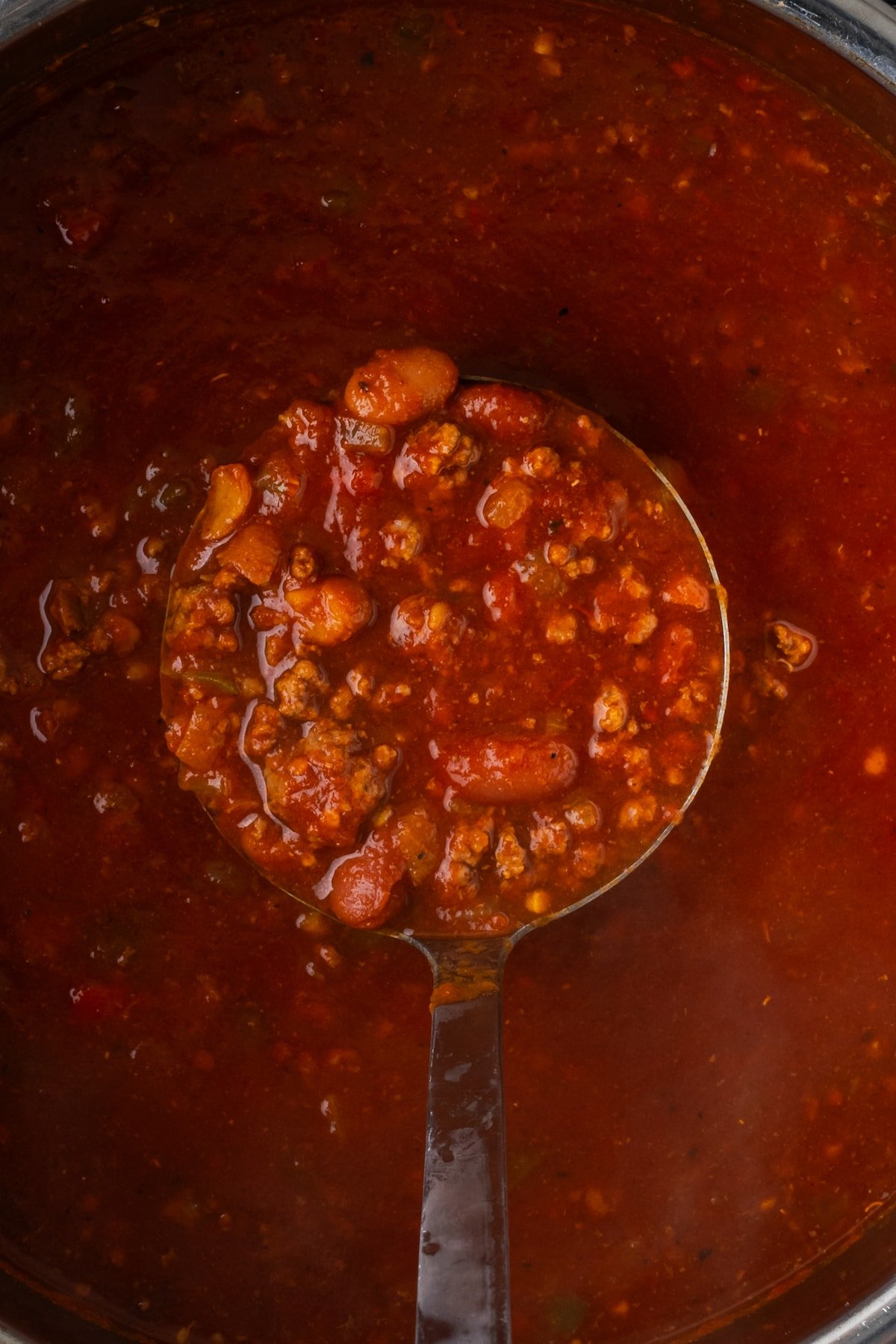 Overhead view of a ladleful of chili held over the instant pot.