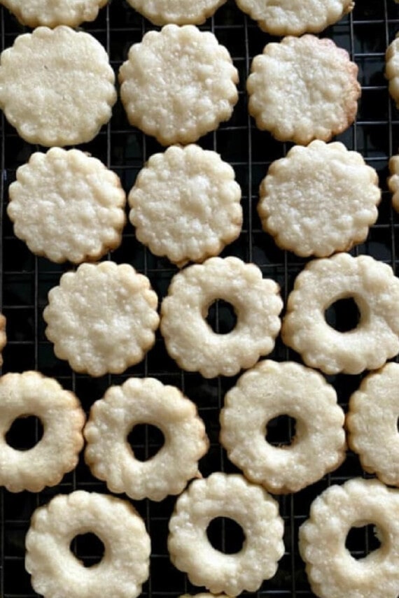 Overhead view of bottom and upper cut-out shortbread cookies cooling on a wire rack.