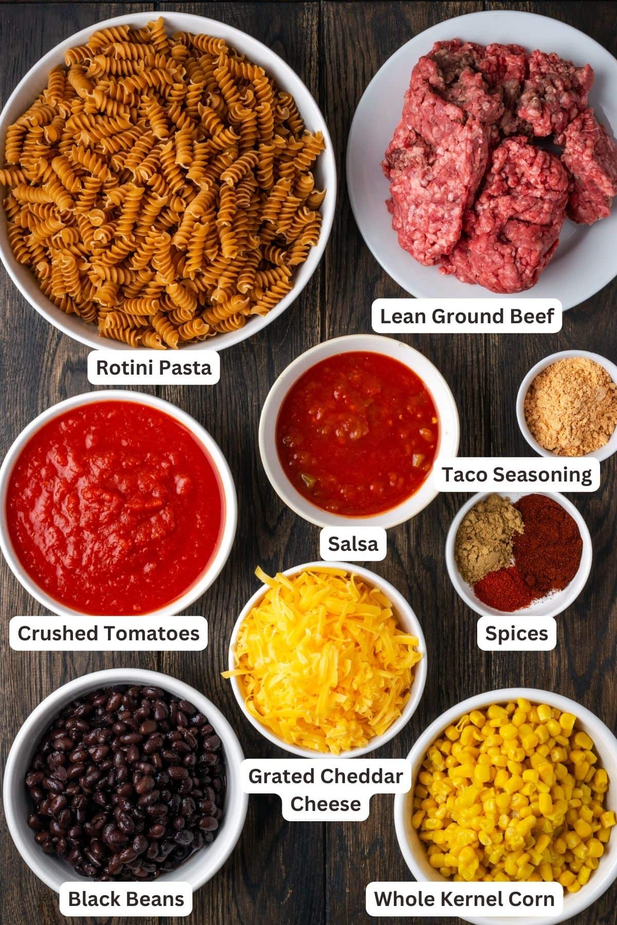 The ingredients for taco pasta with text labels overlaying each ingredient.