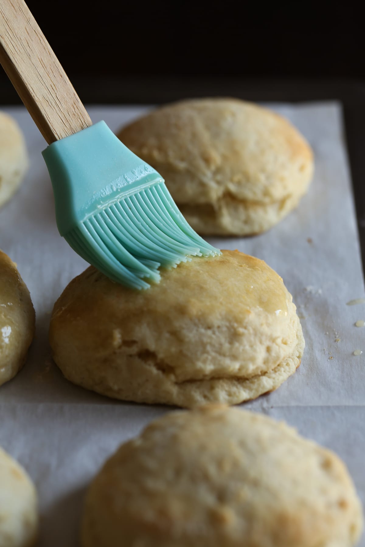 Brushing butter on freshly baked biscuits