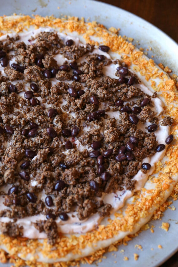 Pizza crust topped with taco meat layered over chipotle cream sauce.