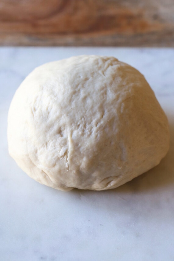 A ball of pizza dough on a countertop.
