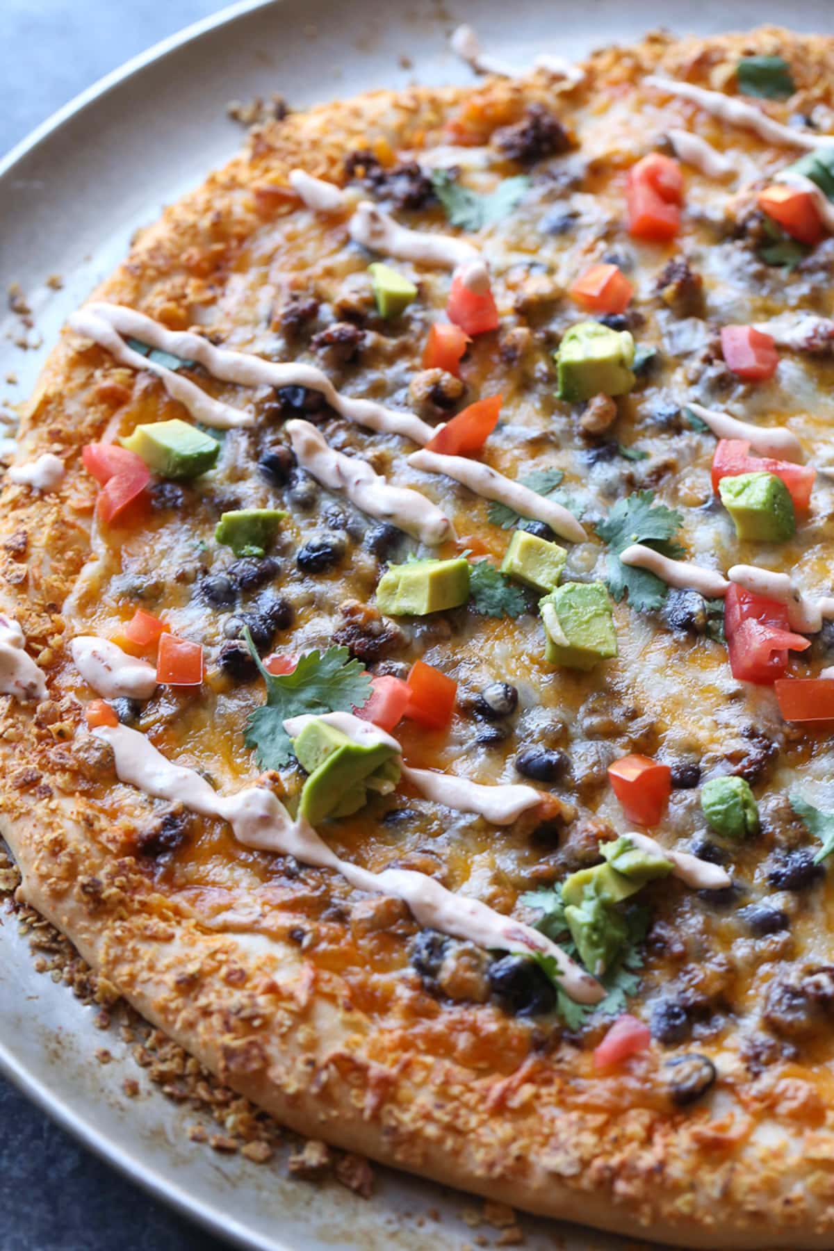 A whole taco pizza on a round baking pan.