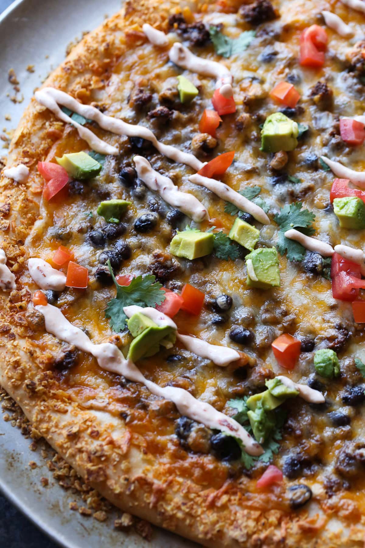 A whole taco pizza on a round baking pan.