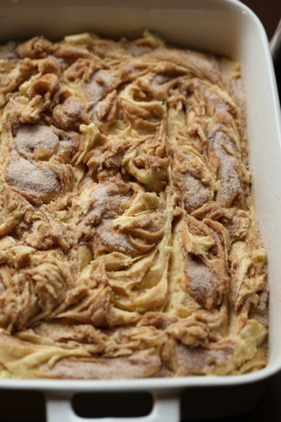 Apple coffee cake batter in a 9x13 baking pan topped with a mixture of brown sugar and cinnamon