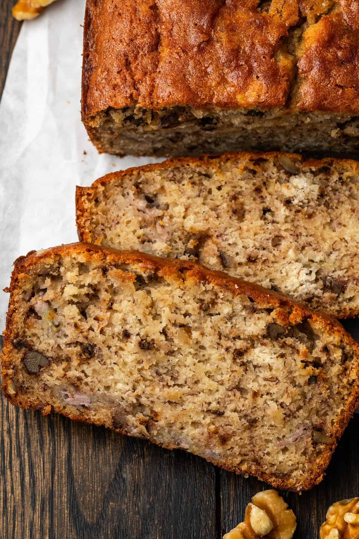 Close up overhead view of a homemade banana bread loaf with slices cut from the end.